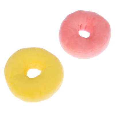 Dvě kulaté plyšové hračky ve tvaru donutu, jedna žlutá a jedna růžová.