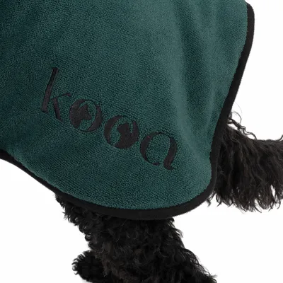 kooa. Dark green towel with black border, visible on a black dog.