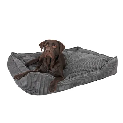 Graues Hundebett mit weichem Stoff, rechteckige Form. Dunkelbrauner Hund liegt entspannt darauf.