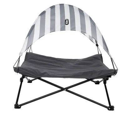 Graues, erhöhtes Haustierbett mit schwarz-weiss gestreiftem Sonnenschutz und stabilen Metallbeinen. Marke Trixie sichtbar auf dem Sonnenschutz.