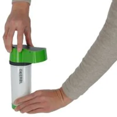 Osoba trzyma dozownik marki Kerbl z zieloną pokrywką i białym pojemnikiem, widoczne logo KERBL na obudowie.