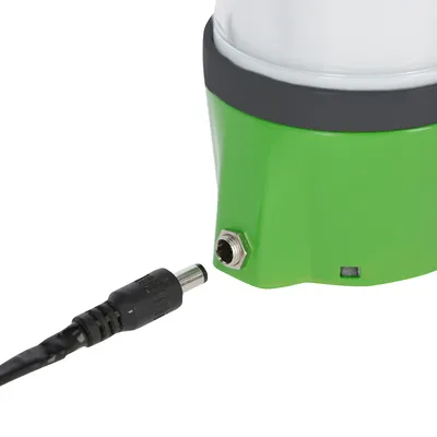 Nærbillede af en grøn enhed med tilslutningsport og et sort kabelstik, egnet til strømforsyning eller forbindelse.