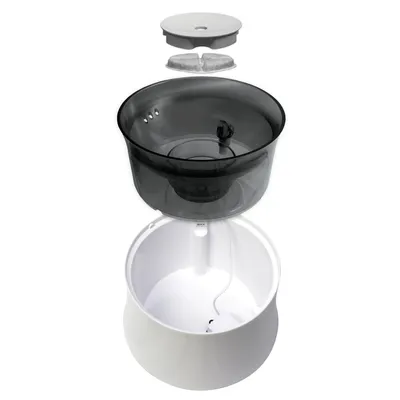 Exploded view of a drinking fountain with removable parts: grey lid, filter insert, black water container and white base with cable connection.