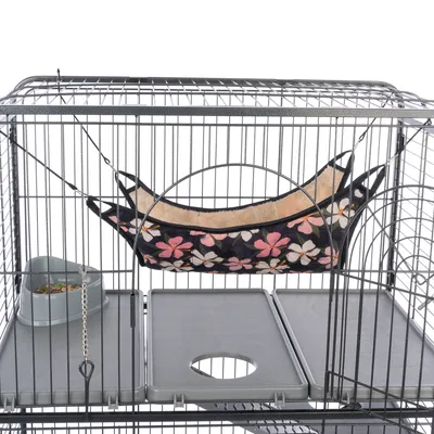 Metallkäfig mit Hängematte im Blumenmuster, Futterstation aus grauem Kunststoff und herausnehmbaren Bodenplatten.