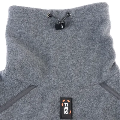 Grauer Fleece-Stoff mit verstellbarem Kordelzug und Tiaki-Logo. Detailansicht des Materials und Designs.