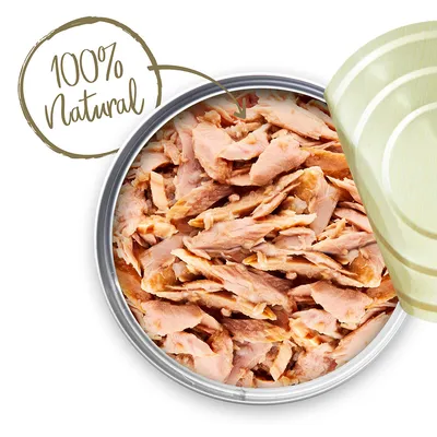 Blik met stukjes vlees, deksel deels geopend. Tekst in beeld: 100% Natural.