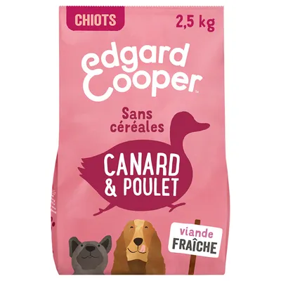 Edgard Cooper Chiots 2,5 kg, sans céréales, canard & poulet, viande fraîche, texte visible sur l’emballage rose avec illustrations de chiens.