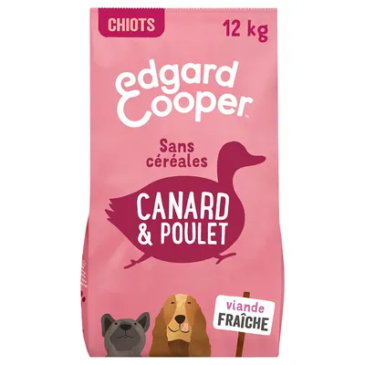 Edgard Cooper Chiots 12 kg, sans céréales, canard & poulet, viande fraîche. Texte visible sur l’emballage rose avec illustrations de chiens.