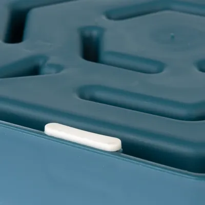 Gros plan sur un plateau en plastique bleu avec surface à reliefs et patin antidérapant blanc visible sur le bord.