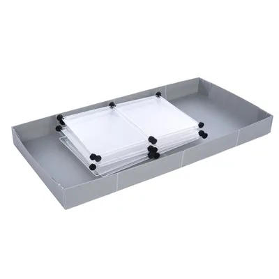 Plateau rectangulaire gris avec plusieurs panneaux transparents empilés, fixés par des attaches noires. Matériaux visibles : plastique et carton.