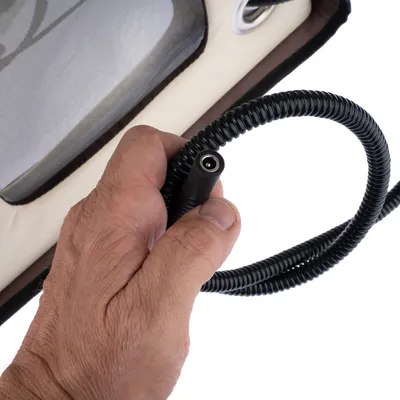 Hand holding a black spiral cable with connector plug, close-up of a product.