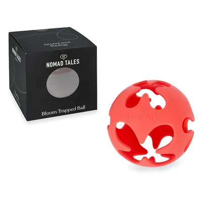 Balle rouge ajourée avec inscription NOMAD TALES, à côté de la boîte noire portant les textes NOMAD TALES et Bloom Trapped Ball. Matériau plastique visible.