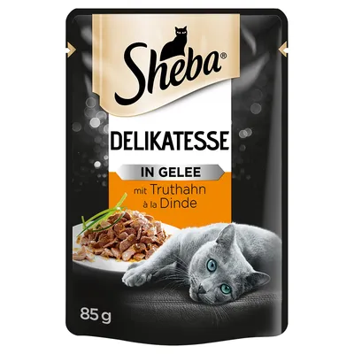 Sheba Delikatesse in Gelee mit Truthahn à la Dinde, sachet de 85 g, image d’un chat gris allongé et d’une assiette de morceaux en gelée.