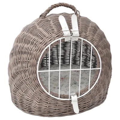 Pyöreä punottu lemmikkikori, jossa valkoinen metalliritiläovi, kaksi valkoista solkikiinnitystä ja kantokahva. Sisällä kukkakuvioinen pehmuste.