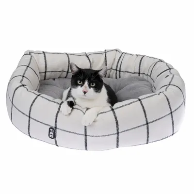 Rond, gevoerd huisdierenbed met wit-zwart ruitpatroon en grijs binnenvlak. Zichtbaar 'Trixie' logo aan de voorkant.