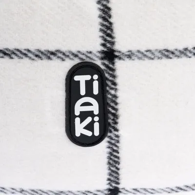 Tiaki-logo op witte stof met zwart ruitpatroon.