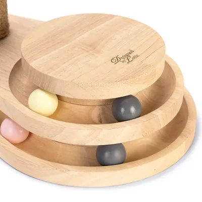 Jouet en bois à trois niveaux avec boules colorées et inscription visible Designed by Lotte sur le dessus.