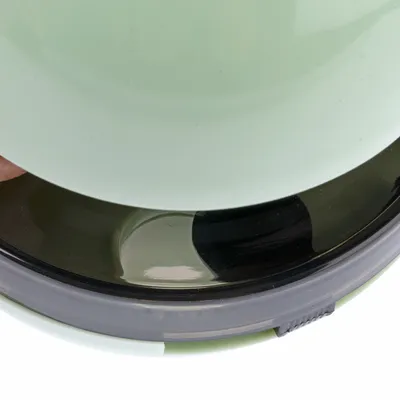 Close-up view of a green food bowl with removable lid and non-slip base.