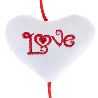 White fabric heart with red 'Love' lettering and decorative heart motif, hanging on a red string.
