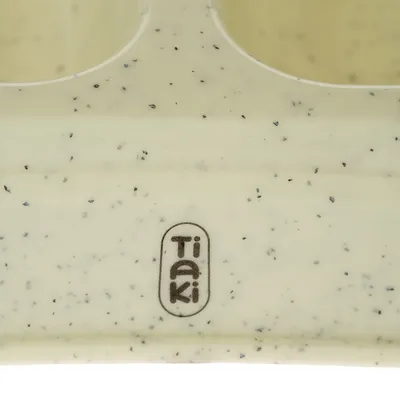 Tiaki-logo pe material crem cu pete negre.