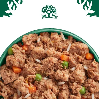 Bowl filled with wet pet food containing visible chunks of meat, peas, carrots and rice.