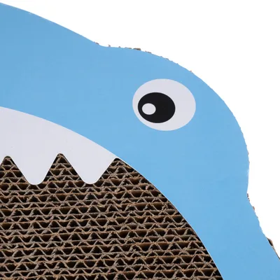 Surface en carton ondulé avec motif bleu représentant une tête d’animal stylisée, dents blanches et œil noir visibles. Aucun texte ou marque apparente.