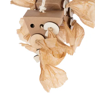 Jouet suspendu en carton, bois et papier froissé, avec ficelle blanche pour accrocher. Plusieurs disques en bois et éléments en papier visibles autour d’un cube en carton.