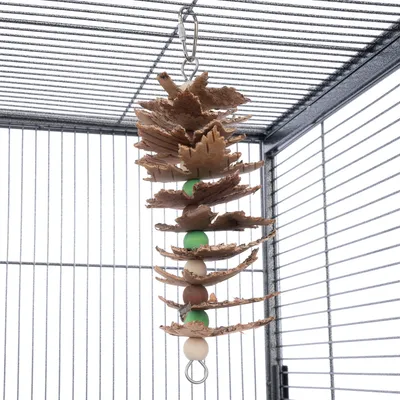 Jouet suspendu pour cage, composé de morceaux de bois naturel et de perles colorées vertes et marron, accroché par un mousqueton métallique.