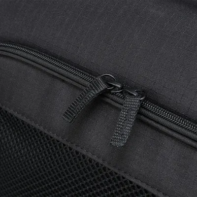 Nahaufnahme eines schwarzen Reißverschlusses mit zwei Zippern an einer Tasche aus Netz- und Stoffmaterial.