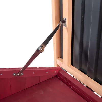 Detailansicht eines Metall-Scharnierarms, der eine Holzklappe mit schwarzer Wand stützt.