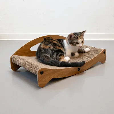 Drveni ležaj za mačke s površinom za grebanje. Mačka leži na ležaju. Marka: Modern.