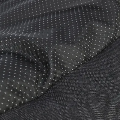 Nahaufnahme eines schwarzen Stoffes mit rutschfesten Punkten und einer strukturierten Oberfläche.