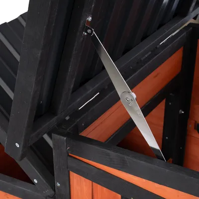 Detailný pohľad na čiernu a oranžovú drevenú konštrukciu s kovovou oporou na stabilizáciu vyklápateľnej strechy.