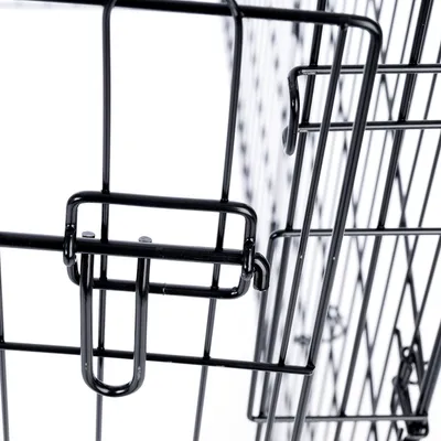 Fermeture en métal d’une porte de cage grillagée, vue rapprochée du système de verrouillage.