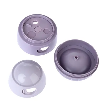 Leksak i lila plast, delbar i tre delar: överdel med transparent lock, mellandel med öppningar och underdel med slät yta.