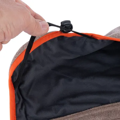 Gros plan sur une main ajustant un cordon élastique noir avec bloqueur sur le bord d’un tissu intérieur noir à liseré orange, extérieur en tissu marron.