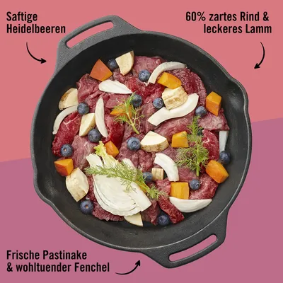 Pfanne mit Zutaten: 60% zartes Rind und leckeres Lamm, saftige Heidelbeeren, frische Pastinake und wohltuender Fenchel.
