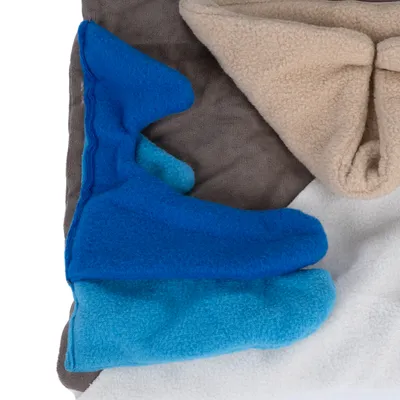 Fleece blankets in various colours: beige, blue, light blue and white, stacked on top of each other.