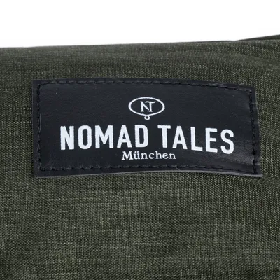 Nomad Tales München. Markenlabel auf grünem Stoff.