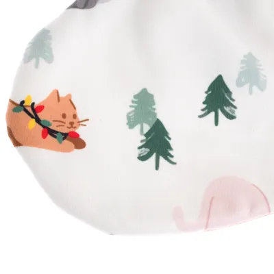 Tygdesign med kattmotiv, julbelysning och granar på vit bakgrund.