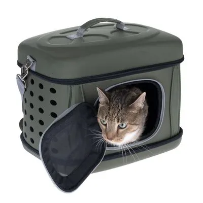 Transportadora rígida verde com pega superior, orifícios de ventilação laterais e porta em rede aberta na frente. Fechos metálicos visíveis.