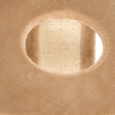 Detail van een krabpaal met beige pluche bekleding en sisal oppervlak zichtbaar door een ronde opening.