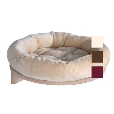 Pyöreä, pehmustettu lemmikkipeti vaalealla kankaalla puisella jalustalla. Näkyvissä kolme värivaihtoehtoa: beige, ruskea ja viininpunainen.