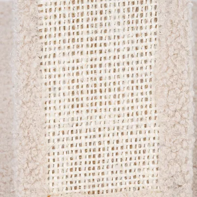 Gros plan sur une surface en sisal tressé entourée de tissu beige bouclé, matériaux visibles utilisés pour accessoires ou arbres à chat.