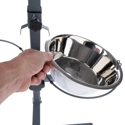 Hand hält eine herausnehmbare Edelstahlschüssel in einem höhenverstellbaren Halter.
