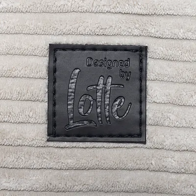 Designed by Lotte. Brand label on beige fabric with striped texture.