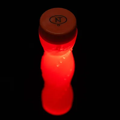 Rød flaske med orange låg og logoet 'NT' på sort baggrund.