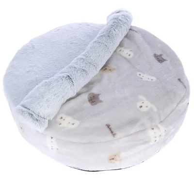 Coussin rond en tissu peluche gris clair avec motifs de têtes de chats et chiens beige et marron, rebord surélevé en fausse fourrure grise.