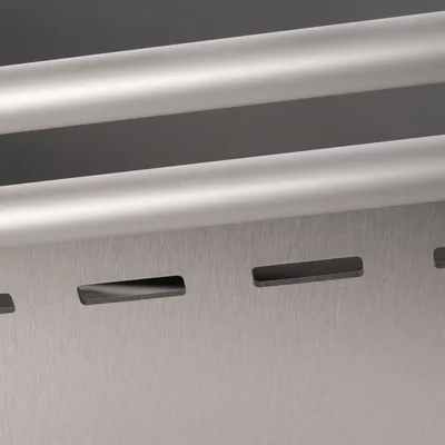 Detailaufnahme eines silbernen Metallbehälters mit Schlitzen und zwei horizontalen Stangen.
