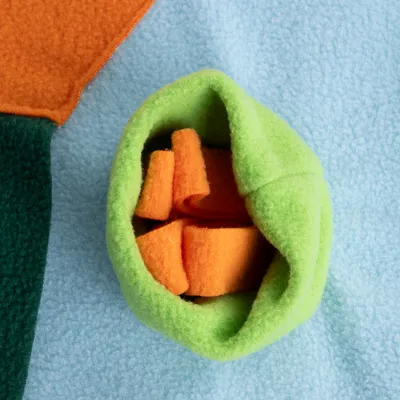 Grønt og orange legetøj af fleece-materiale på blå baggrund, egnet til interaktiv leg.